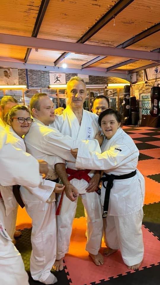 Karate practitioners posing together with a certificate