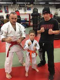 Three generations posing together on the dojo floor