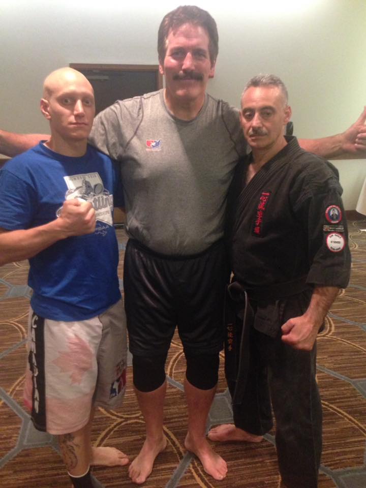 Three men posing together during a martial arts gathering