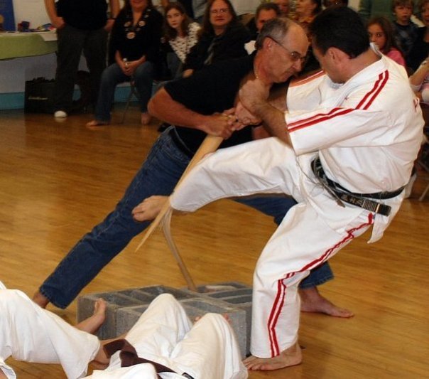 A karate technique demonstrated during a seminar, with seated students watching