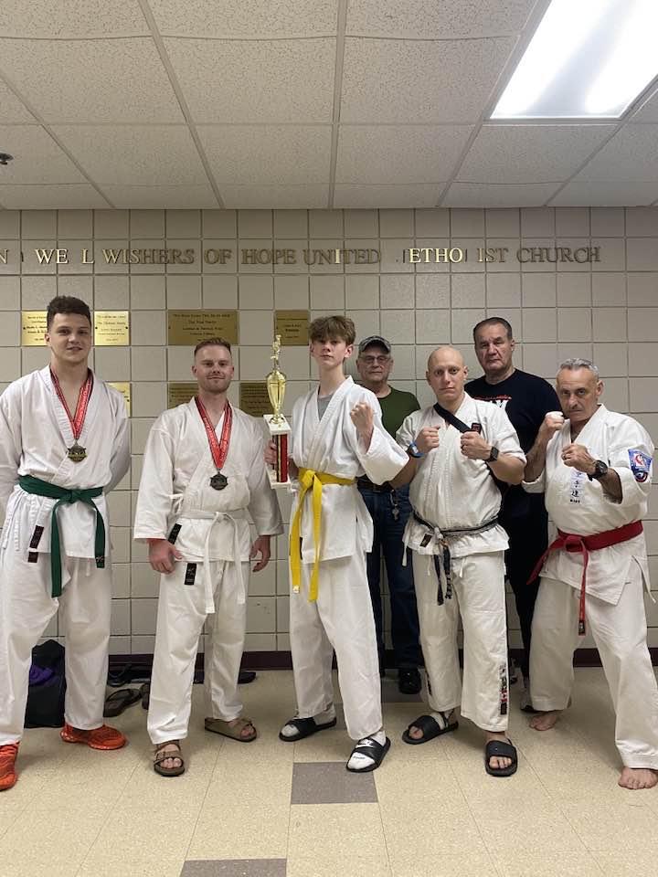 Competitors and instructors posing with tournament trophies