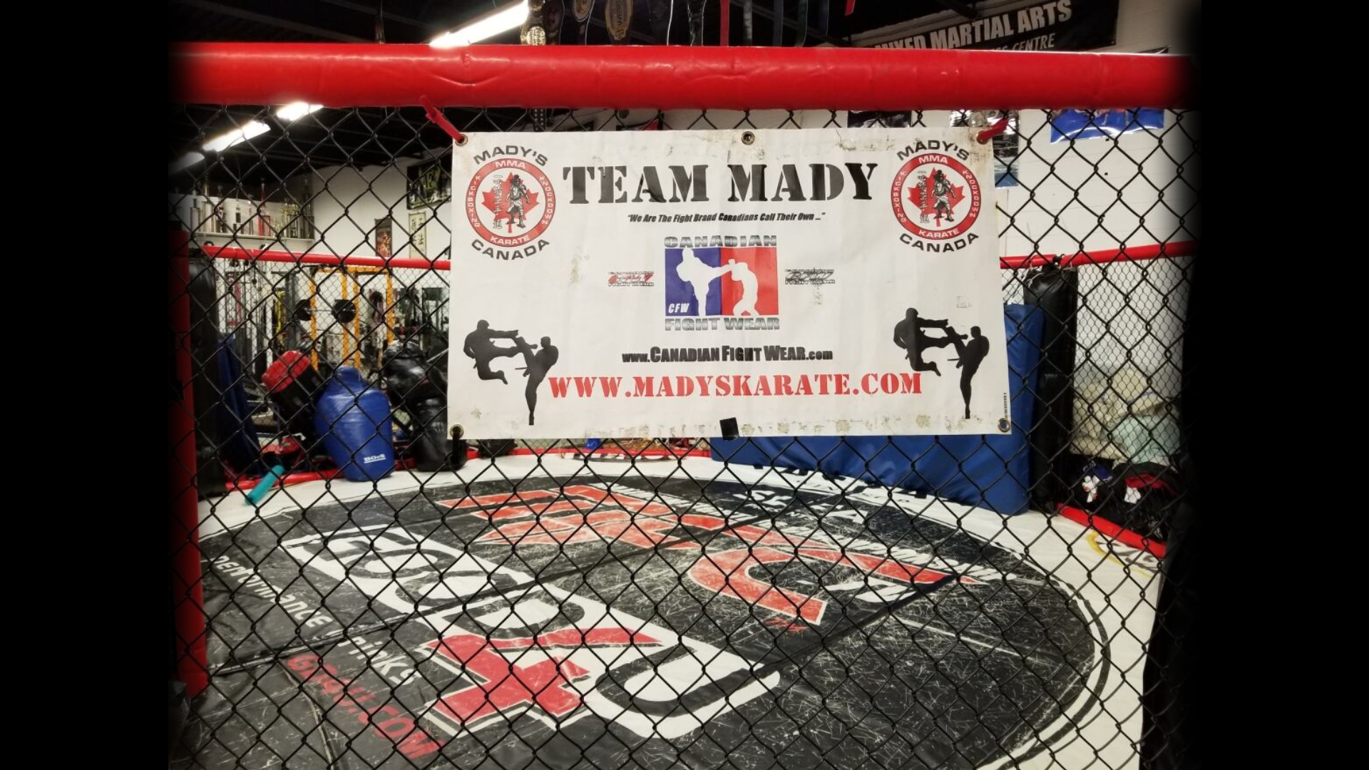 Team Mady banner beside a martial arts cage