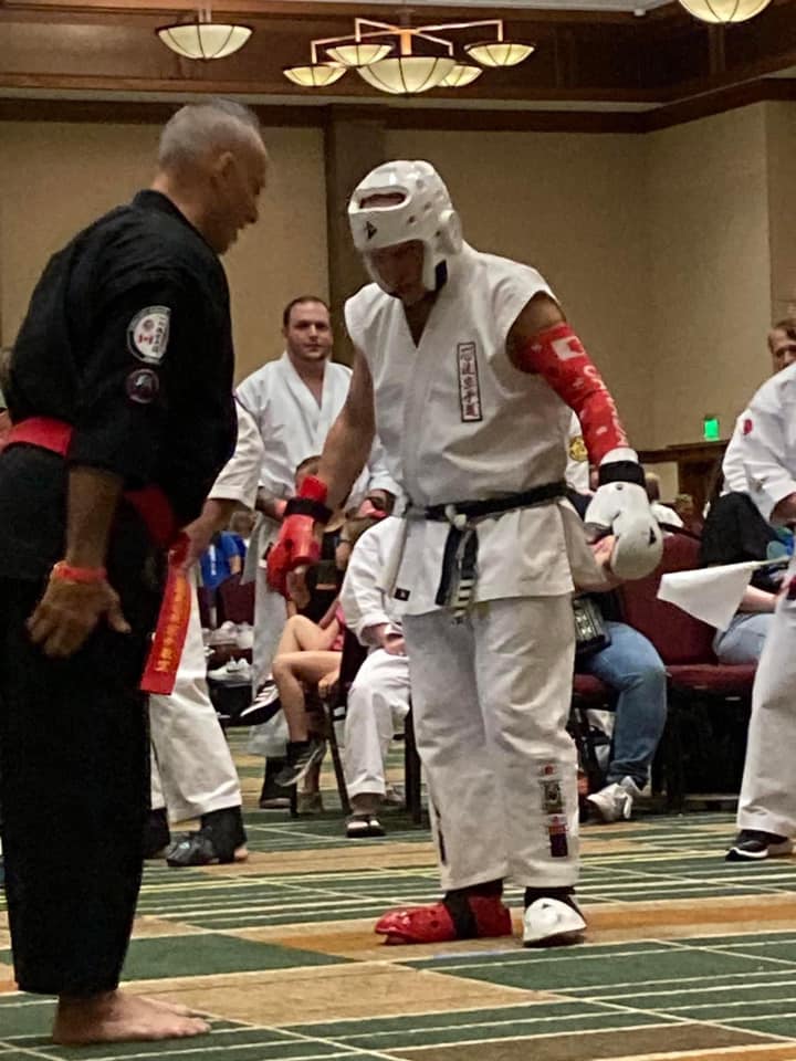 Team members congratulating a young karate competitor