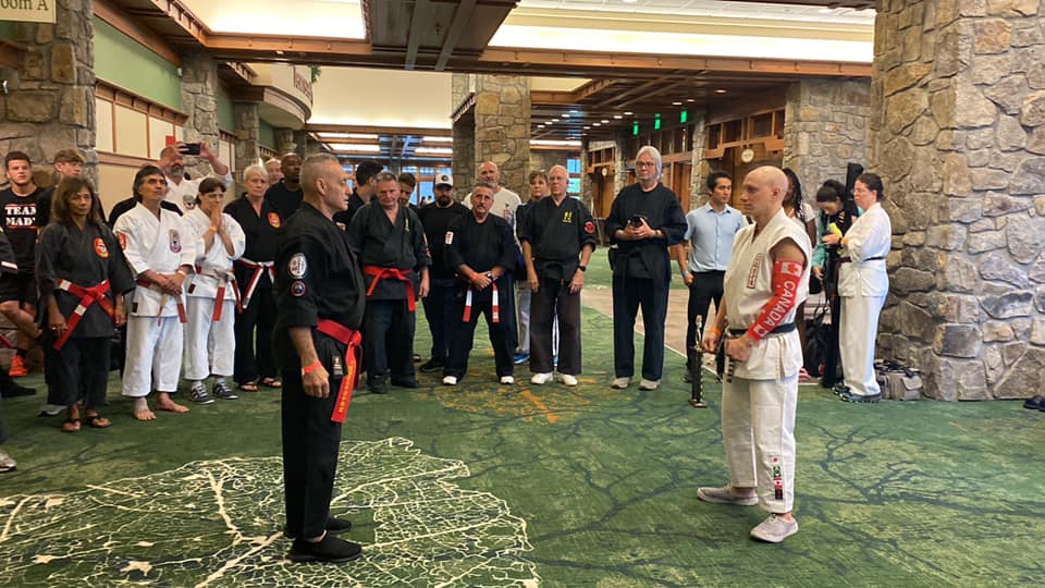 Black belt leading a line of competitors at a martial arts event