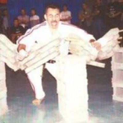 Archival photograph of a martial artist performing a breaking demonstration