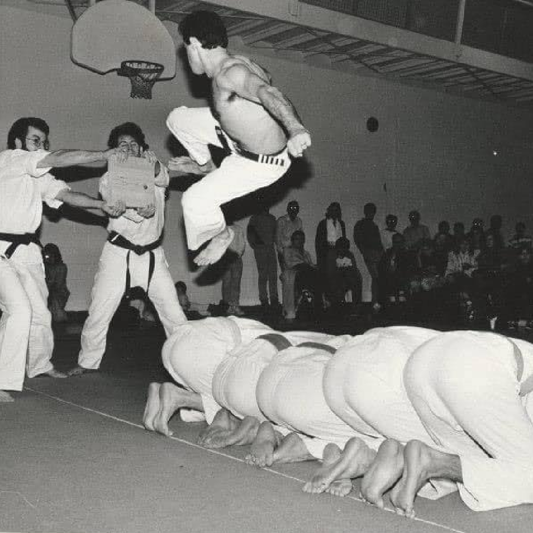 Black-and-white photograph of a karate breaking demonstration
