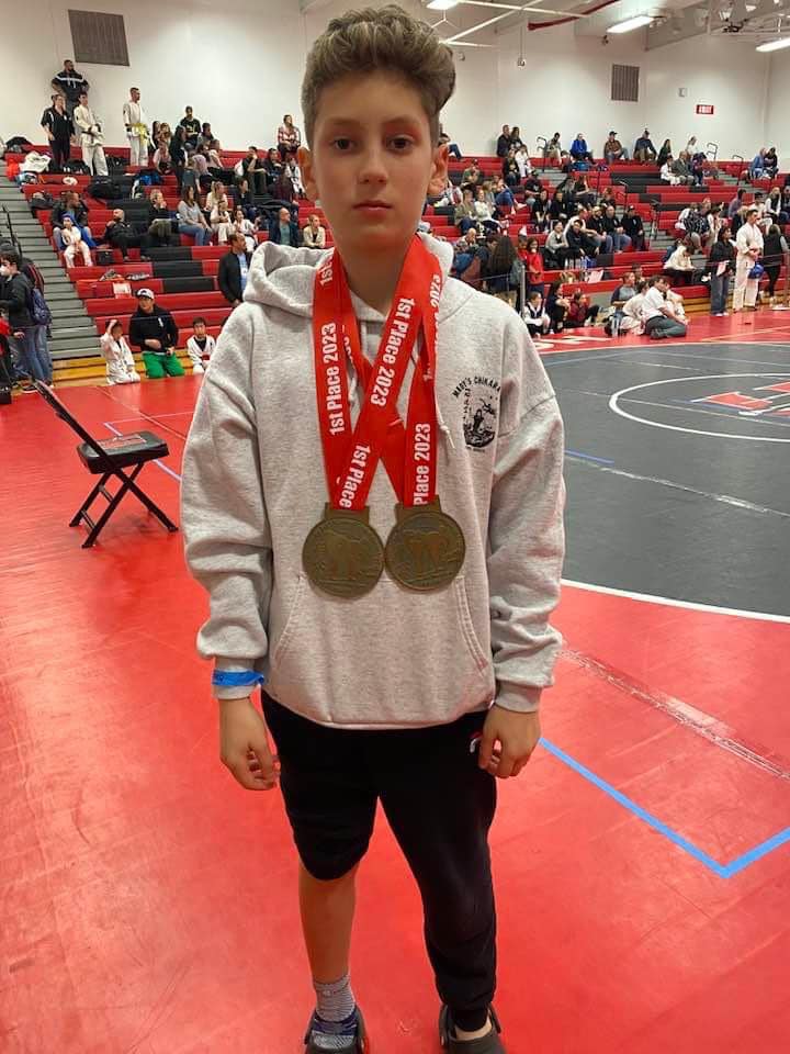 Young Team Mady competitor displaying medals at a tournament