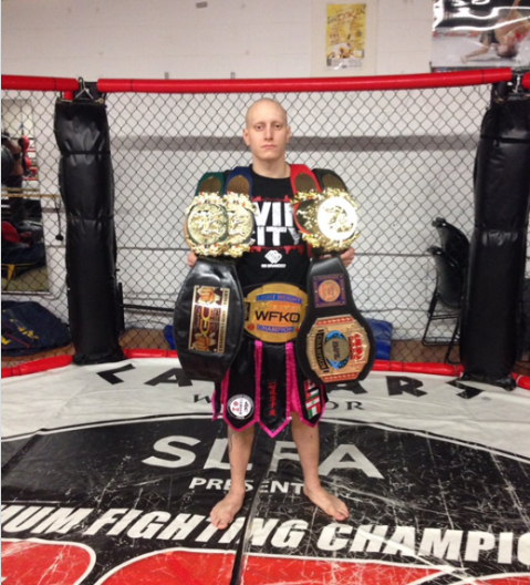Chucky Mady standing with championship belts in the ring