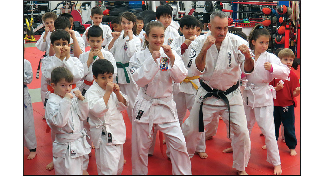 Karate instructor with young competitors at a tournament